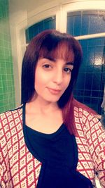 Close-up portrait of young woman at home