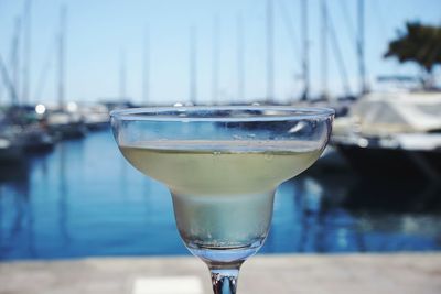 Close-up of drink at harbor against sky