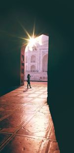 Woman walking in mosque during sunny day
