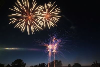 Low angle view of firework display at night