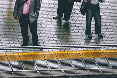 Low section of people waiting for a train at the station platform