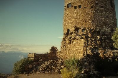 Weathered fortified wall against blue sky