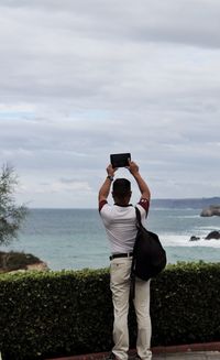 Rear view of man photographing sea