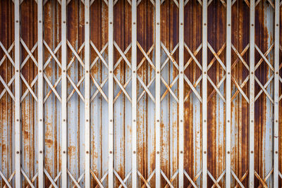 Full frame shot of rusty metal gate against wall