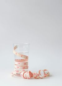 Close-up of glass jar on table against white background