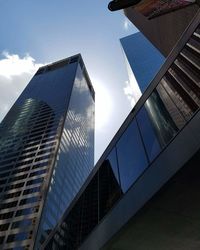 Low angle view of modern glass building against sky