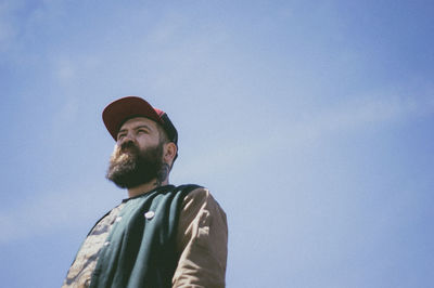 Low angle view of man looking away against sky