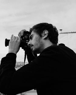 Man photographing against sky