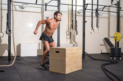 Shirtless man exercising at gym