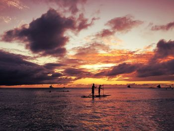 Scenic view of sea against cloudy sky during sunset