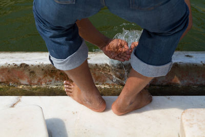 Low section of man standing on water