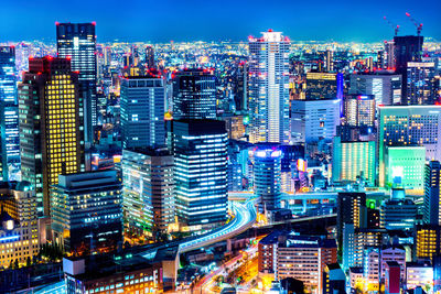 Illuminated cityscape against sky at night