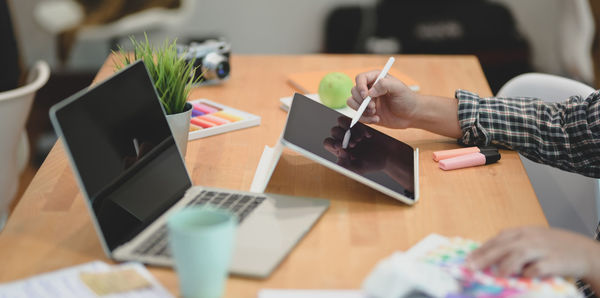 Midsection of woman using laptop on table