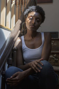 Portrait of a young woman sitting in a staircase