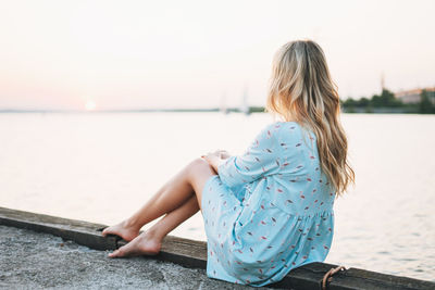 Rear view of woman looking at sea against sky