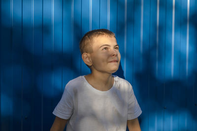 Dreams on the horizon, a boy's hopeful gaze against the blue wall