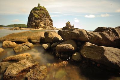 View of rock formation on beach against sky