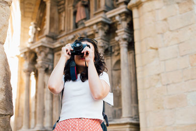 Low angle view of woman photographing