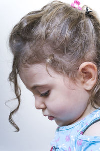 Close-up of cute girl against white background