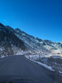 Scenic view of snowcapped mountains against clear blue sky