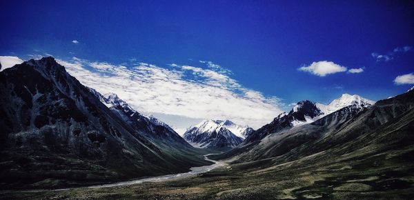 Scenic view of snowcapped mountains against blue sky