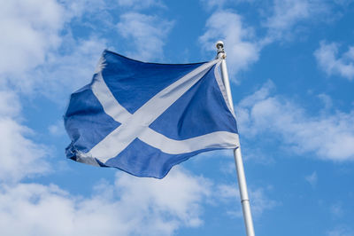 Low angle view of flag against blue sky