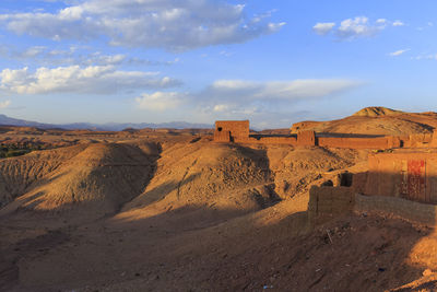 Scenic view of desert against cloudy sky