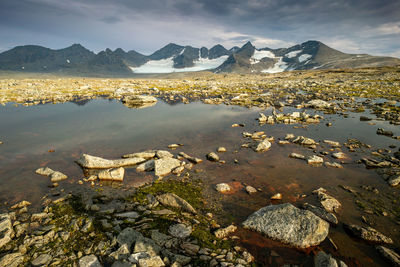 Scenic view of sea and mountains against sky