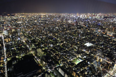 High angle view of illuminated cityscape against sky at night