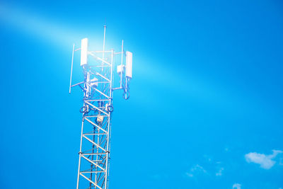 Low angle view of communications tower against blue sky