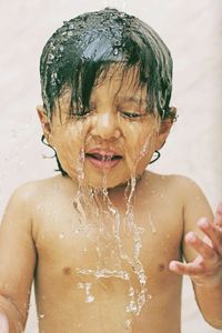 Midsection of shirtless boy in water