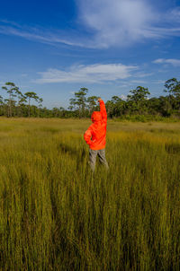 Rear view of person on field against sky