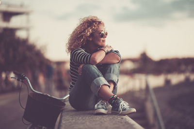 Woman looking away while sitting outdoors