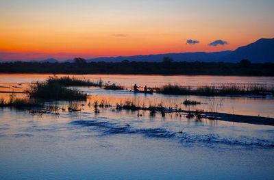 Scenic view of lake against romantic sky at sunset