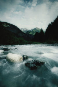 Scenic view of waterfall against sky