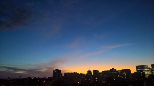 Silhouette buildings against sky during sunset