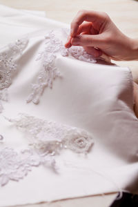 Cropped hand of woman stitching wedding dress