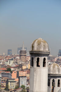 Buildings in city against clear sky