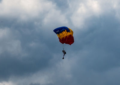 Low angle view of person paragliding against sky