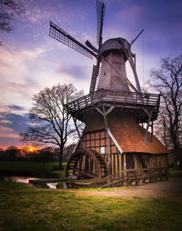 Traditional windmill on landscape against sky