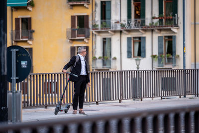 Man walking on street against building in city