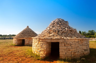 Old building on field against clear sky