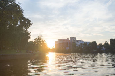 Sunset over river with buildings in background