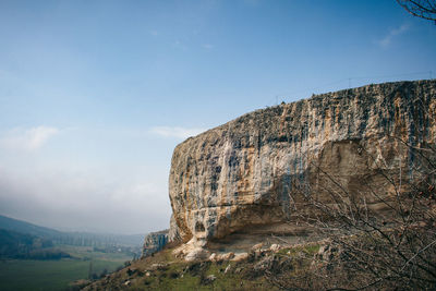 Low angle view of rocky mountain against sky