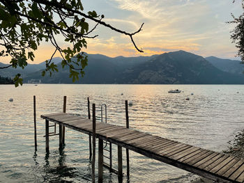 Pier over lake against sky during sunset