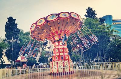 Carousel in amusement park against sky