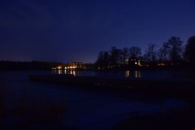 Scenic view of lake against clear blue sky at night