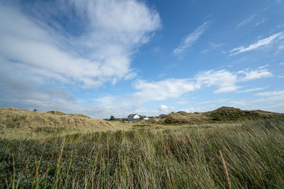 Scenic view of field dunes against sky