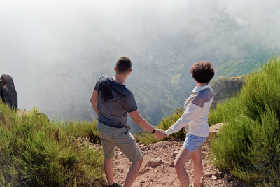 Rear view of man and woman standing on mountain