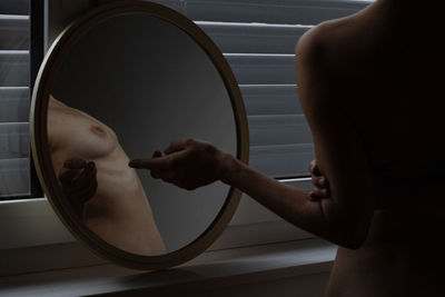 Midsection of shirtless man holding woman at home